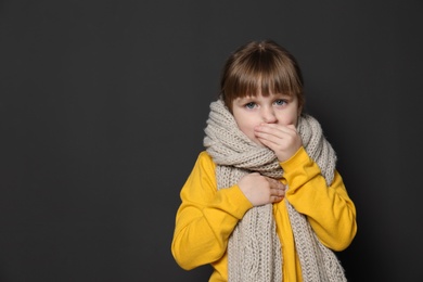 Photo of Cute little girl coughing against dark background. Space for text