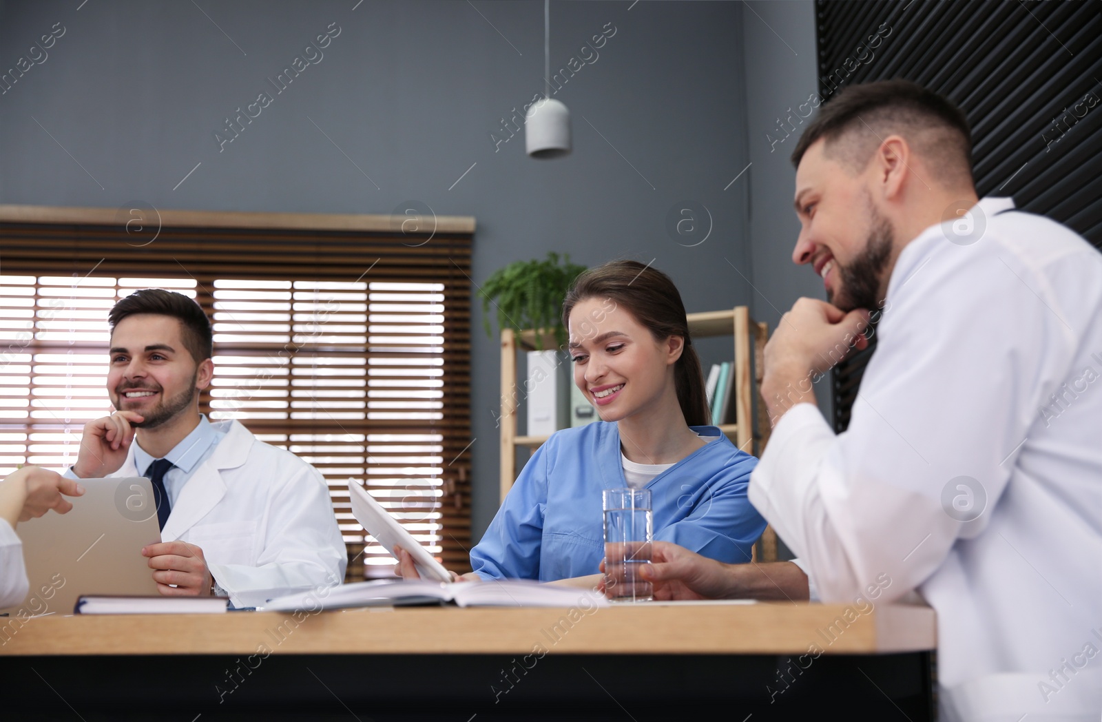 Photo of Team of professional doctors having meeting in office