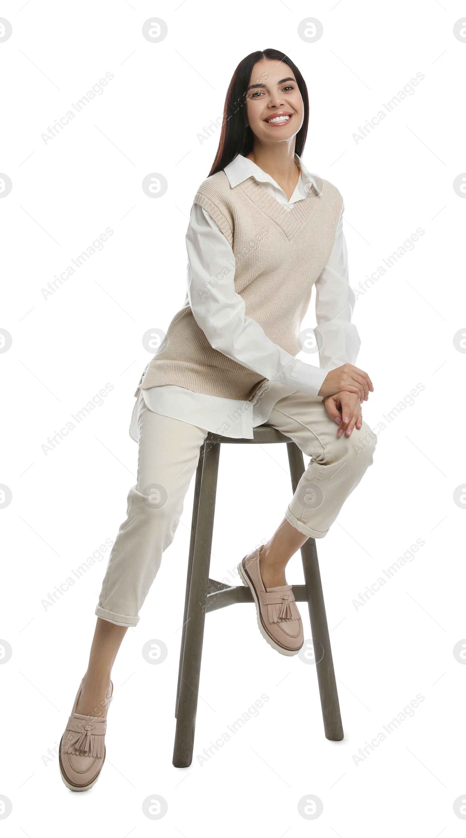 Photo of Beautiful young woman sitting on stool against white background