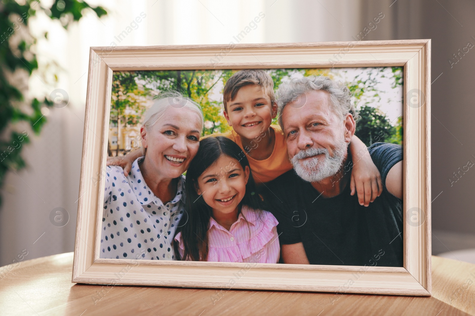 Photo of Framed family photo on wooden table in room