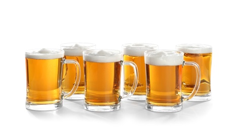 Photo of Glass mugs of beer on white background