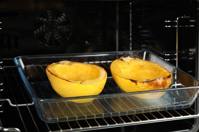 Photo of Baking dish with halves of cooked spaghetti squash in oven