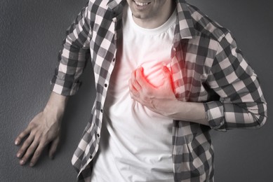 Man having heart attack on dark background, closeup view