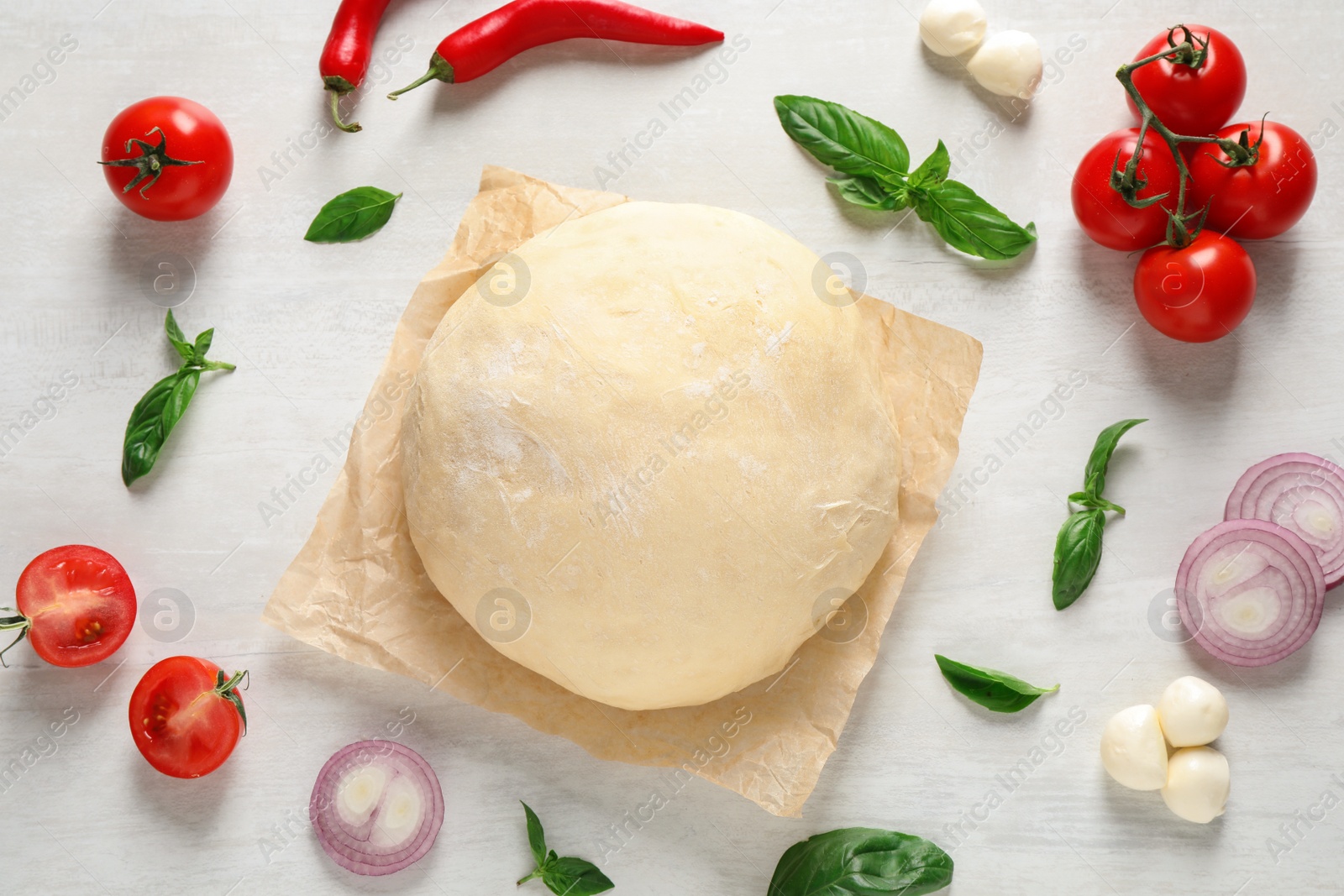 Photo of Flat lay composition with dough and fresh ingredients for pizza on white wooden table