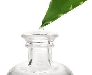 Photo of Aloe juice dripping from leaf into bottle on white background