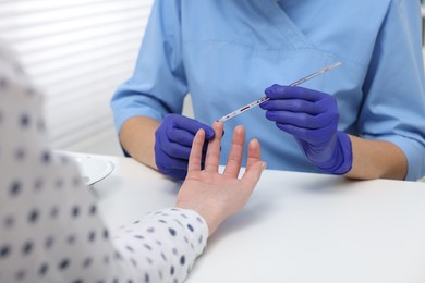 Photo of Laboratory testing. Doctor taking blood sample from patient at white table in hospital, closeup