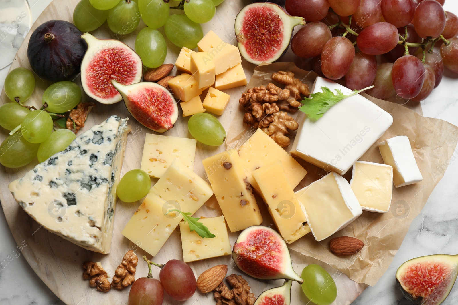 Photo of Set of different snacks with ripe figs served on board, top view