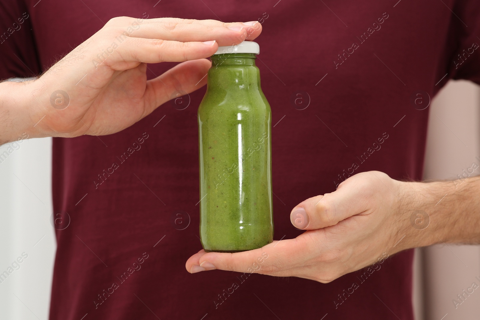 Photo of Man holding bottle of delicious fresh smoothie, closeup