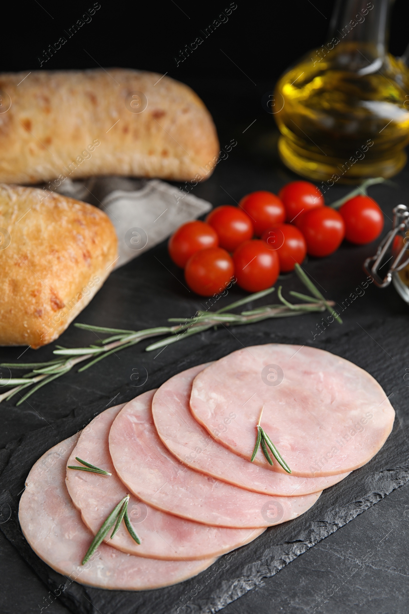 Photo of Slices of tasty ham on black table