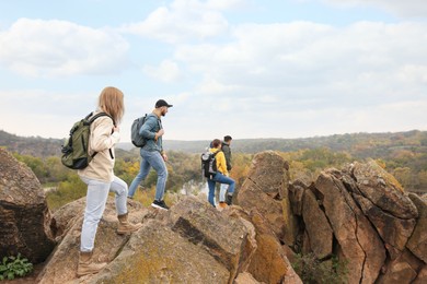 Photo of Group of hikers with backpacks at top of mountain