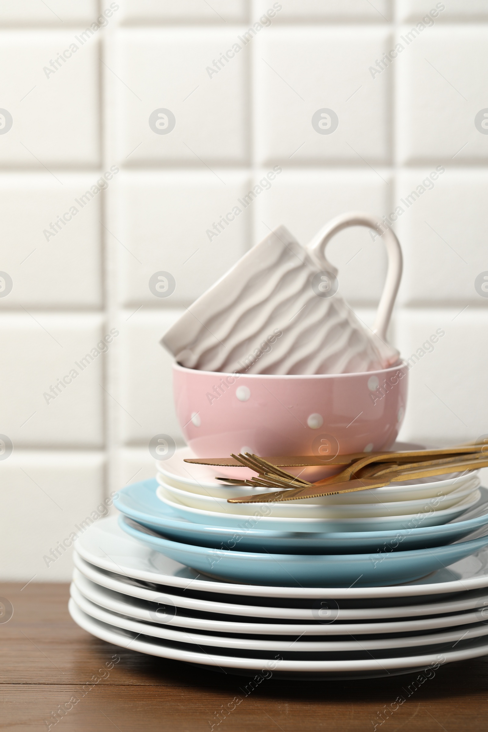 Photo of Beautiful ceramic dishware, cup and cutlery on wooden table