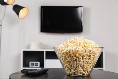 Popcorn and TV remote controls on table in living room