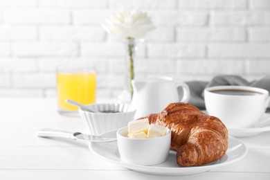 Photo of Fresh croissant and butter on white wooden table. Tasty breakfast