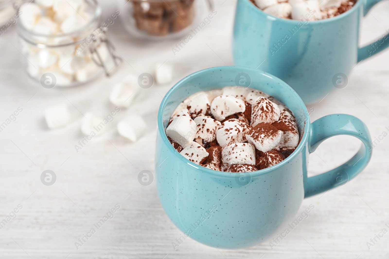 Photo of Cup of chocolate milk with marshmallows on wooden table