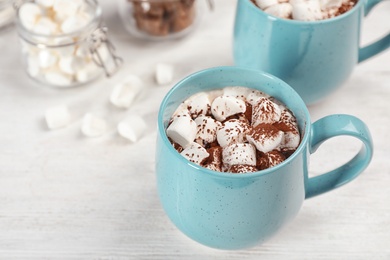 Photo of Cup of chocolate milk with marshmallows on wooden table