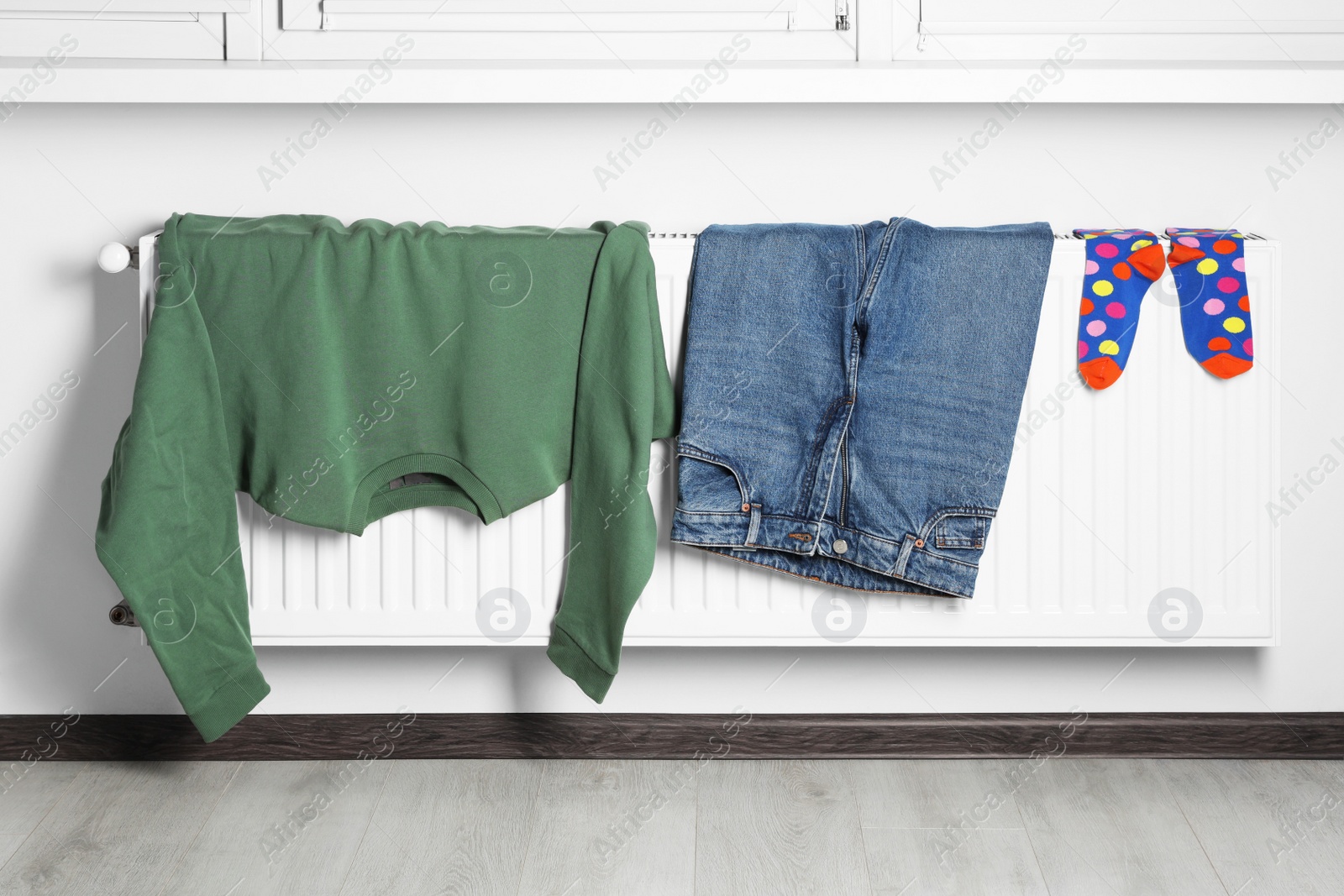 Photo of Clothes hanging on white radiator in room