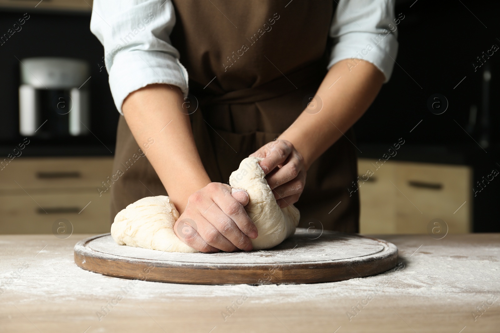 Photo of Female baker preparing bread dough at table, closeup