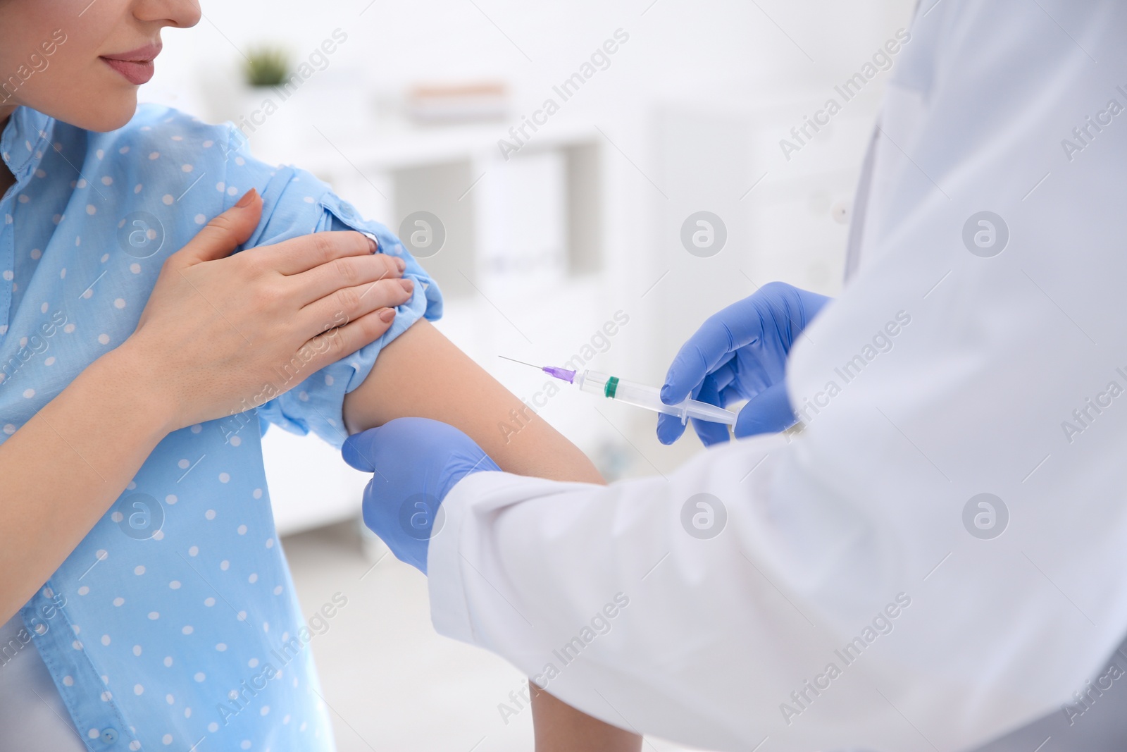 Photo of Doctor giving injection to patient in hospital, closeup. Vaccination concept