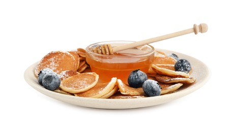 Photo of Delicious mini pancakes cereal with blueberries and honey on white background