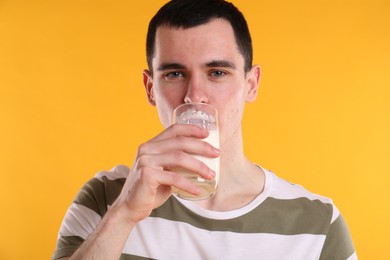 Photo of Milk mustache left after dairy product. Man drinking milk on orange background