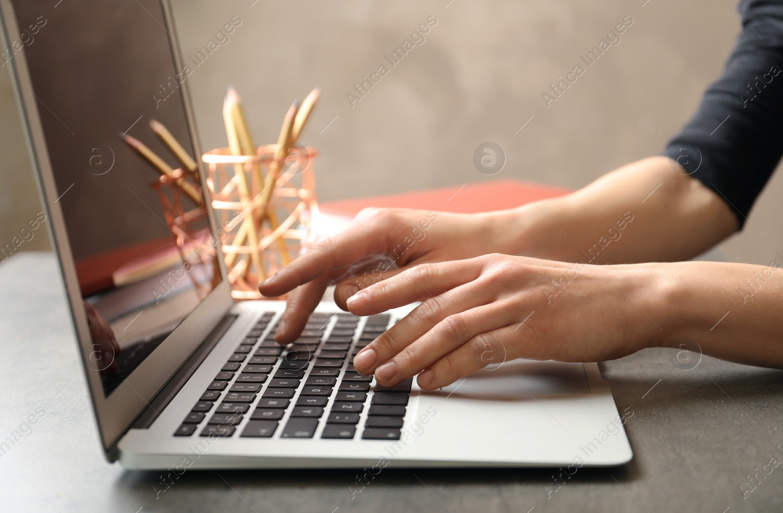 Photo of Woman using modern laptop at table, closeup