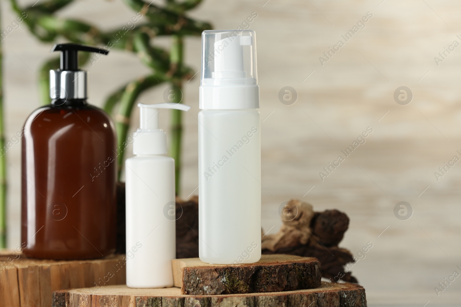 Photo of Bottles of face cleansing products on wooden stand