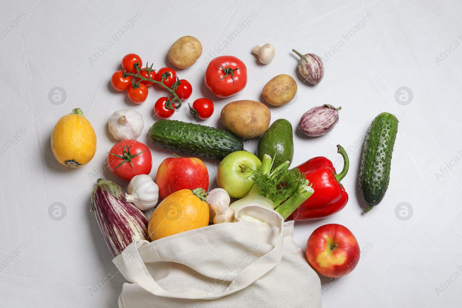 Photo of Bag with fresh vegetables and fruits on light background, flat lay