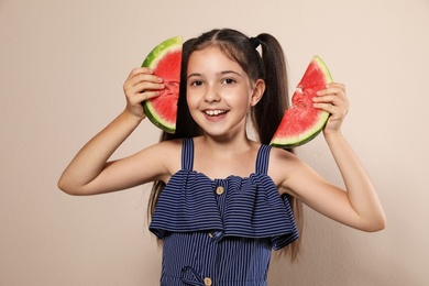 Photo of Cute little girl with watermelon on beige background