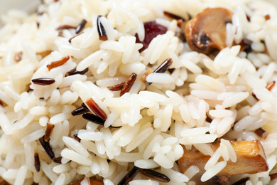 Photo of Delicious rice pilaf with mushrooms as background, closeup