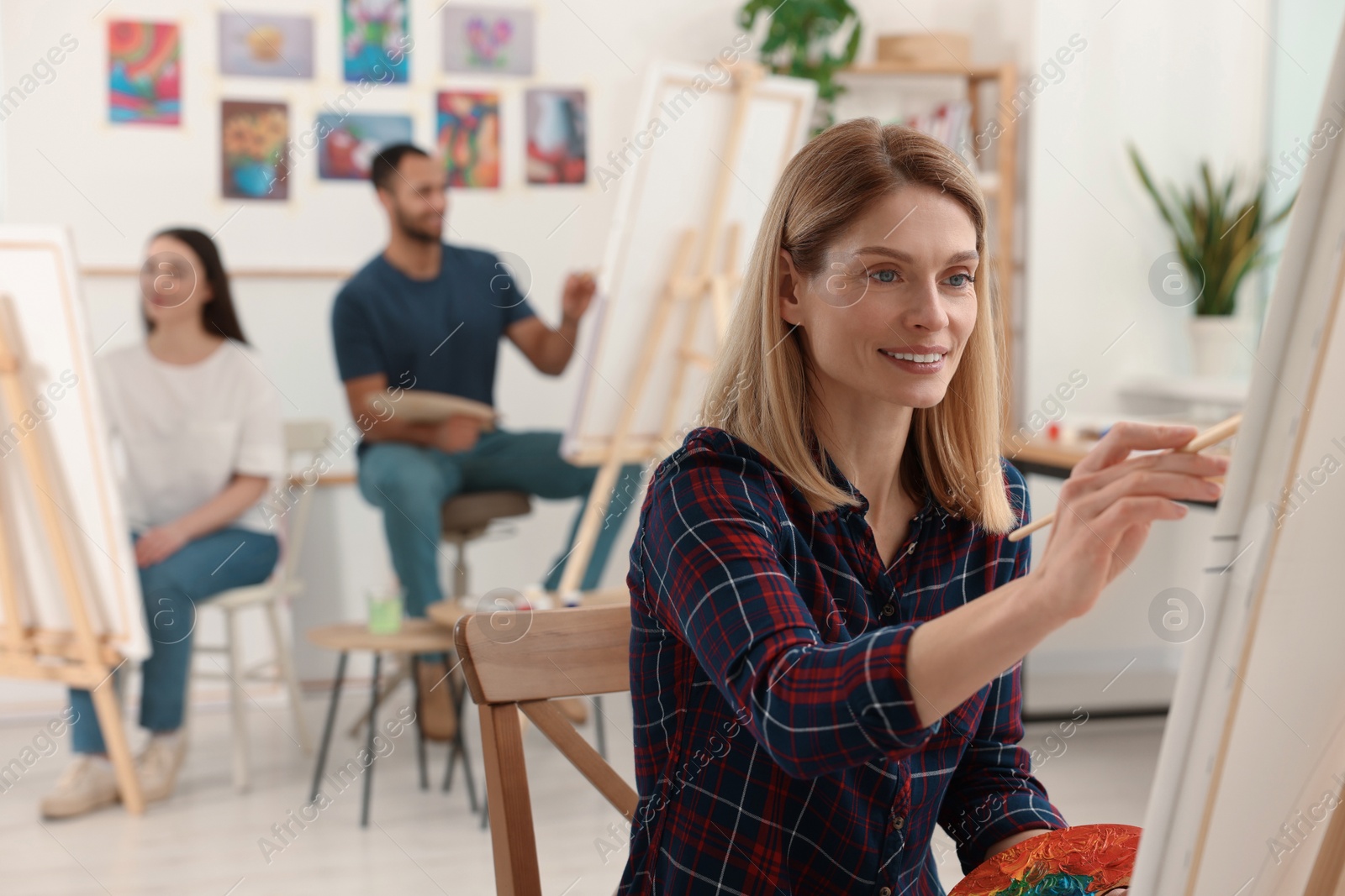 Photo of Group of students attending painting class in studio. Creative hobby