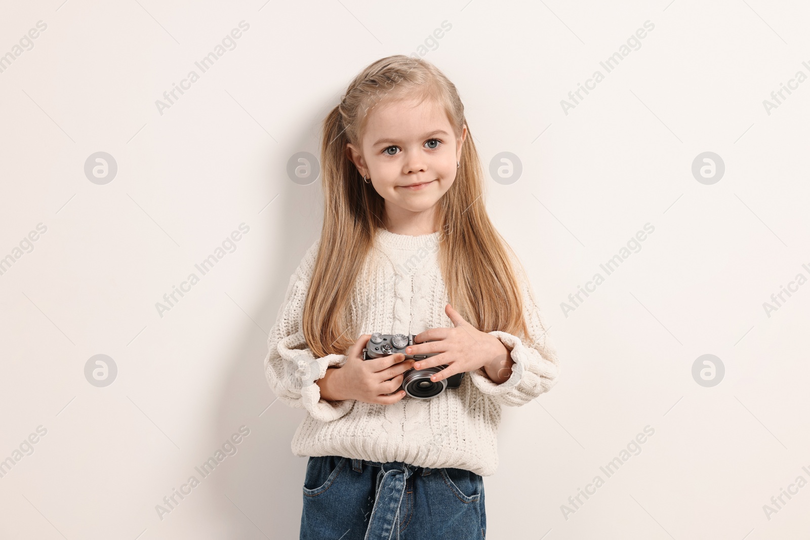 Photo of Fashion concept. Stylish girl with vintage camera on white background