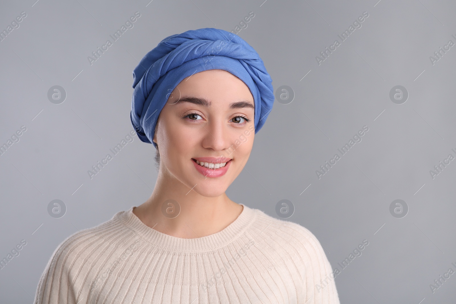 Photo of Portrait of smiling woman with cancer on grey background