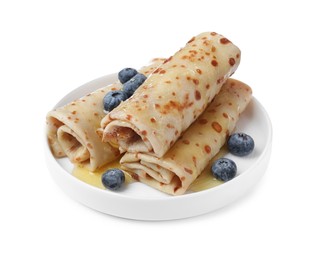 Photo of Delicious crepes with blueberries and honey on white background