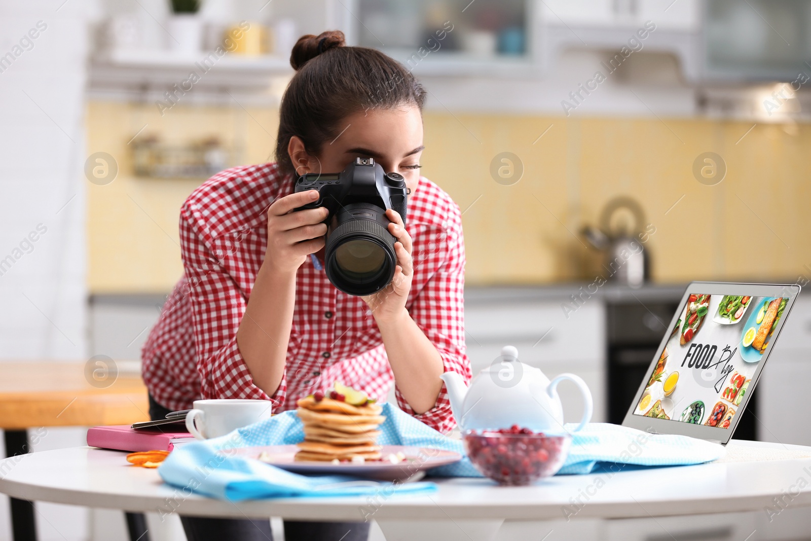 Photo of Food blogger taking photo of her breakfast at table