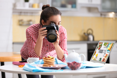 Food blogger taking photo of her breakfast at table
