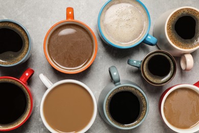 Photo of Cups of fresh aromatic coffee on light grey table, flat lay