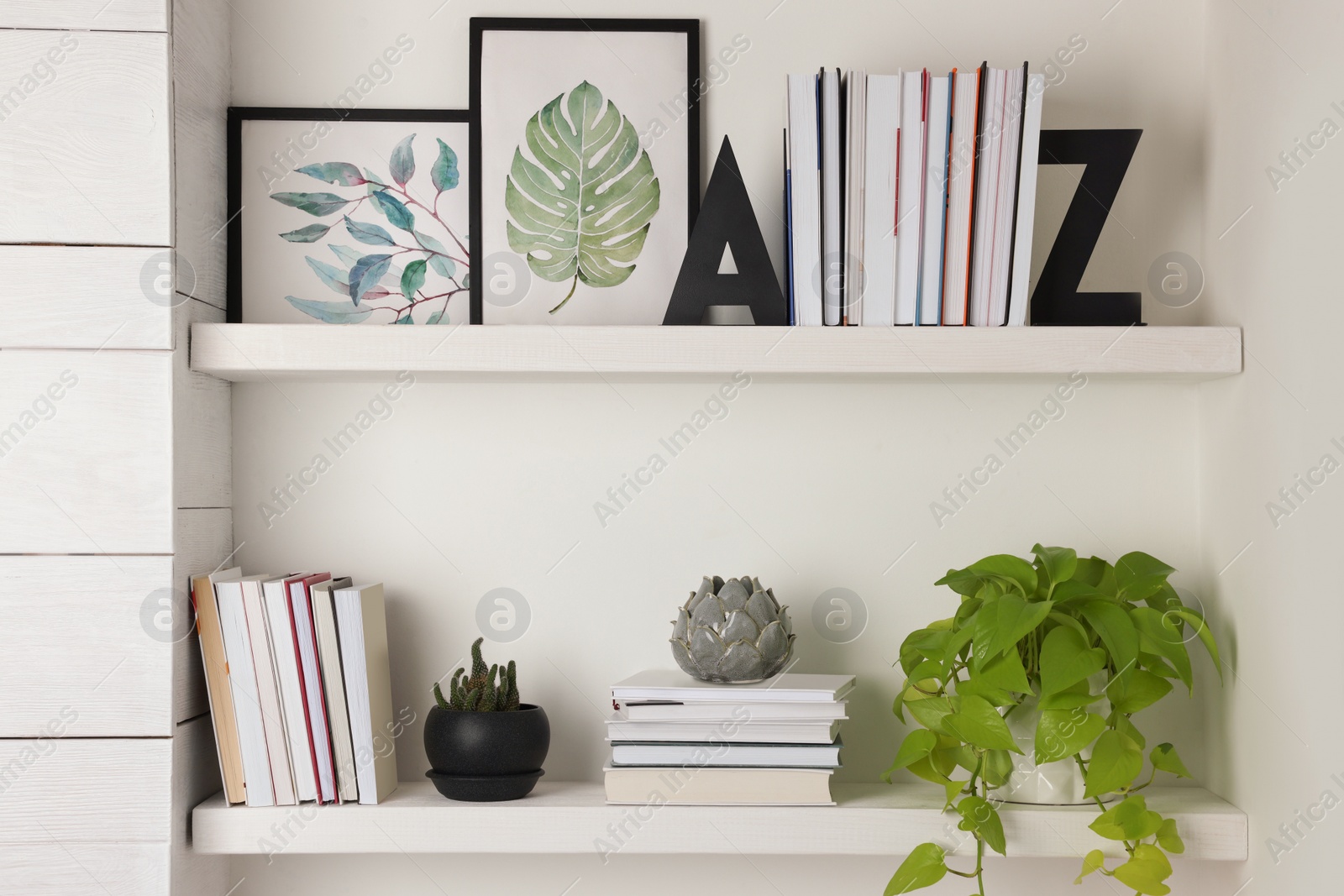 Photo of Bookends and other decor on shelves indoors. Interior design