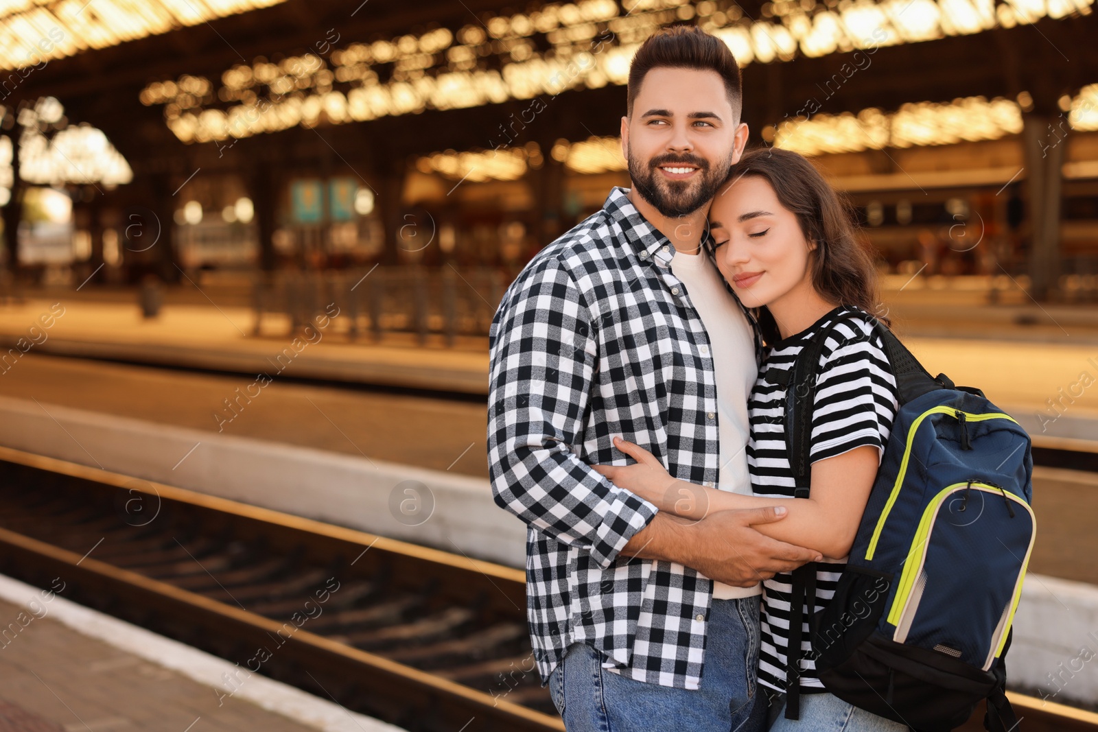 Photo of Long-distance relationship. Beautiful couple on platform of railway station, space for text