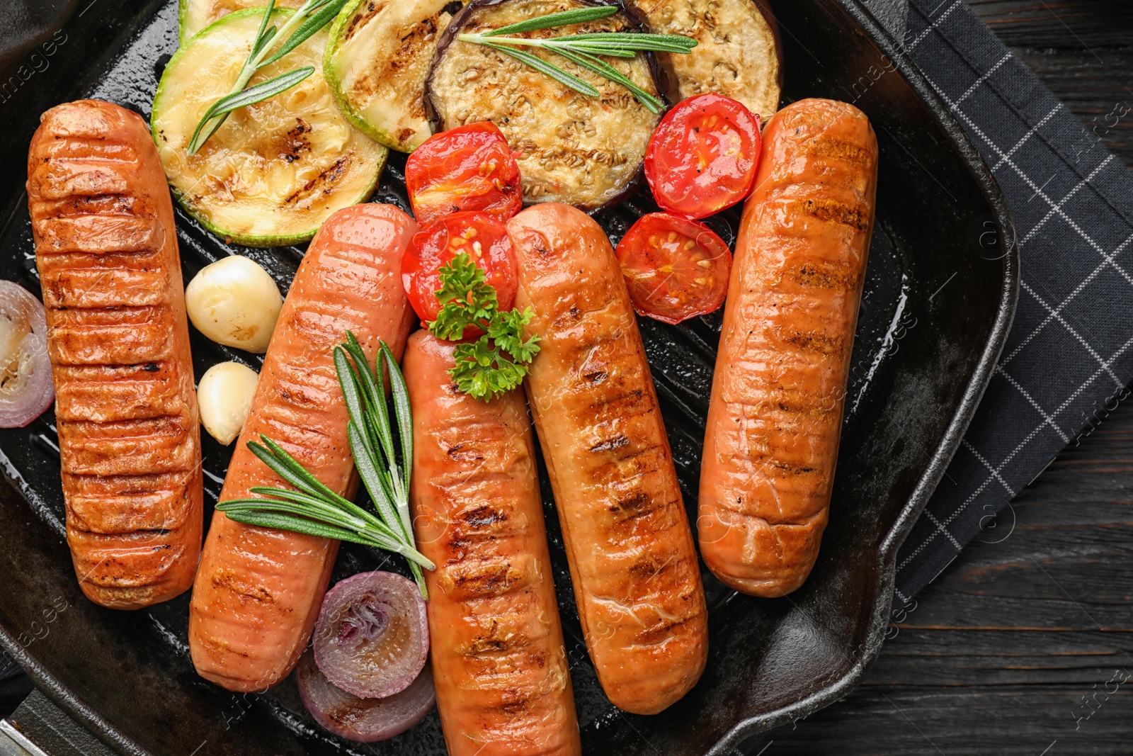 Photo of Delicious sausages with vegetables on grill pan, top view. Barbecue food