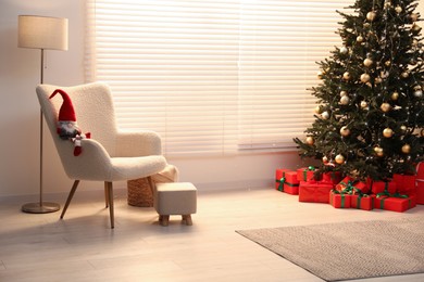 Photo of Beautifully wrapped gift boxes under Christmas tree in living room