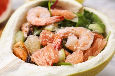 Delicious pomelo salad with shrimps in half of fruit, closeup