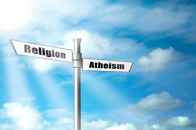 Image of Choice between atheism and religion. Signpost with words pointing in different directions against beautiful sky
