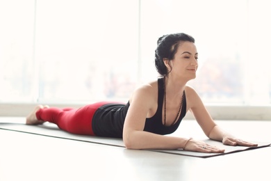 Photo of Sporty woman practicing yoga indoors