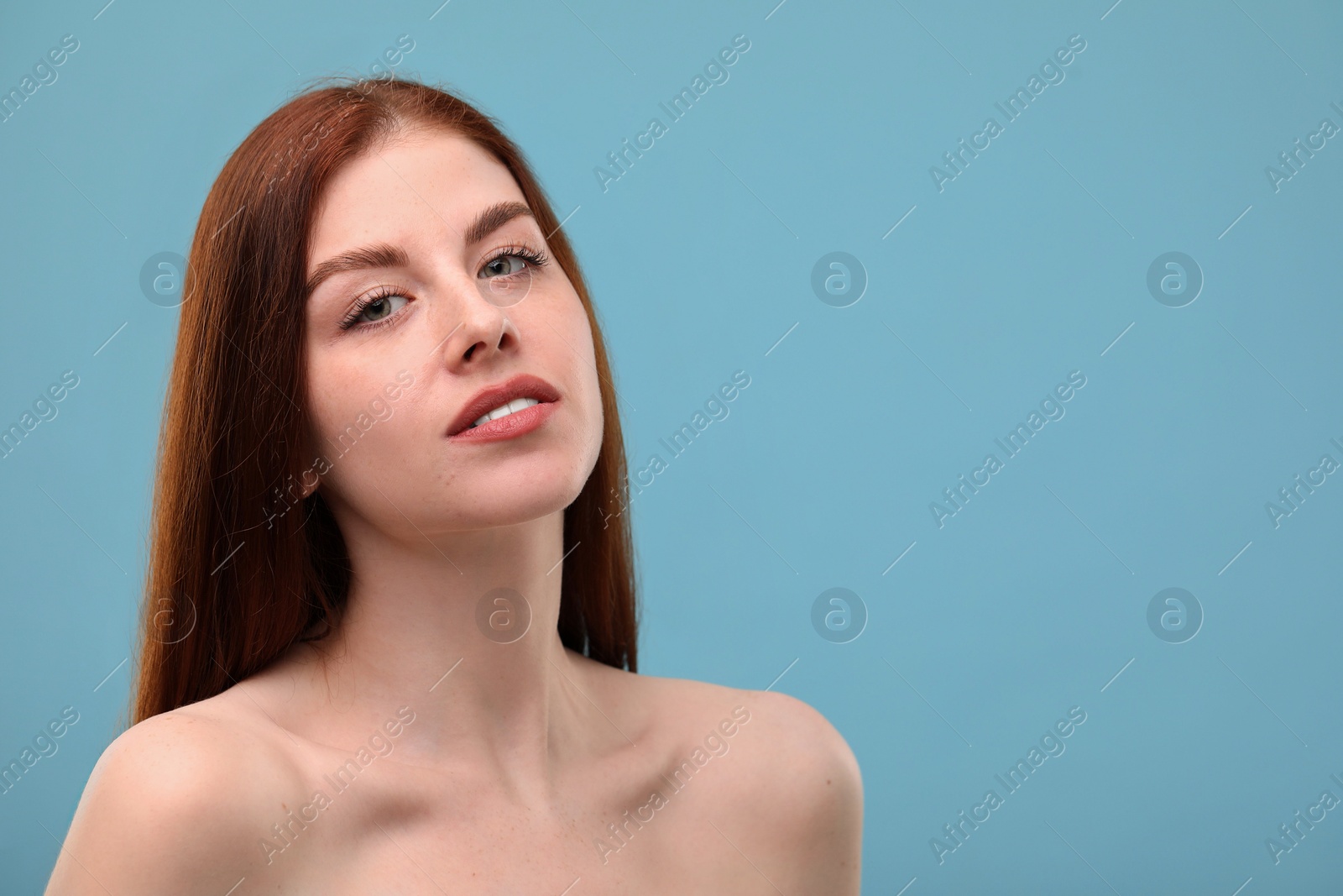 Photo of Portrait of beautiful woman with freckles on light blue background. Space for text
