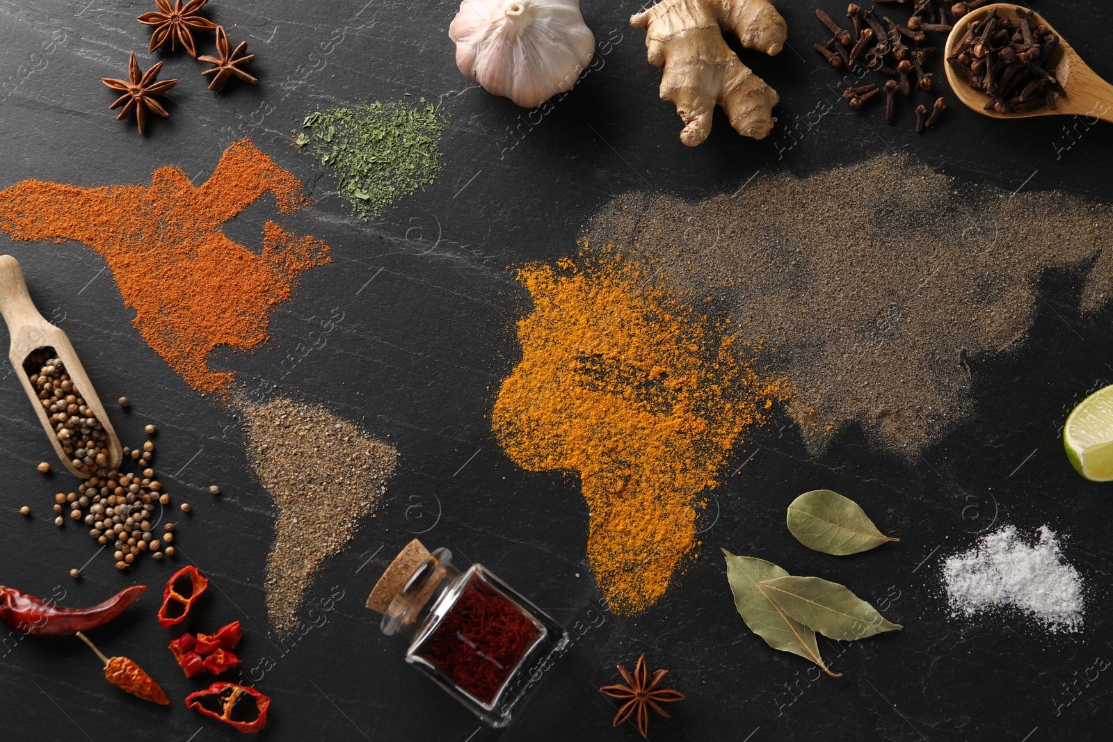 Photo of World map of different spices and products on dark textured table, flat lay