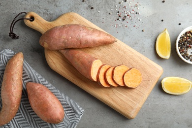 Photo of Flat lay composition with sweet potatoes and products on grey background