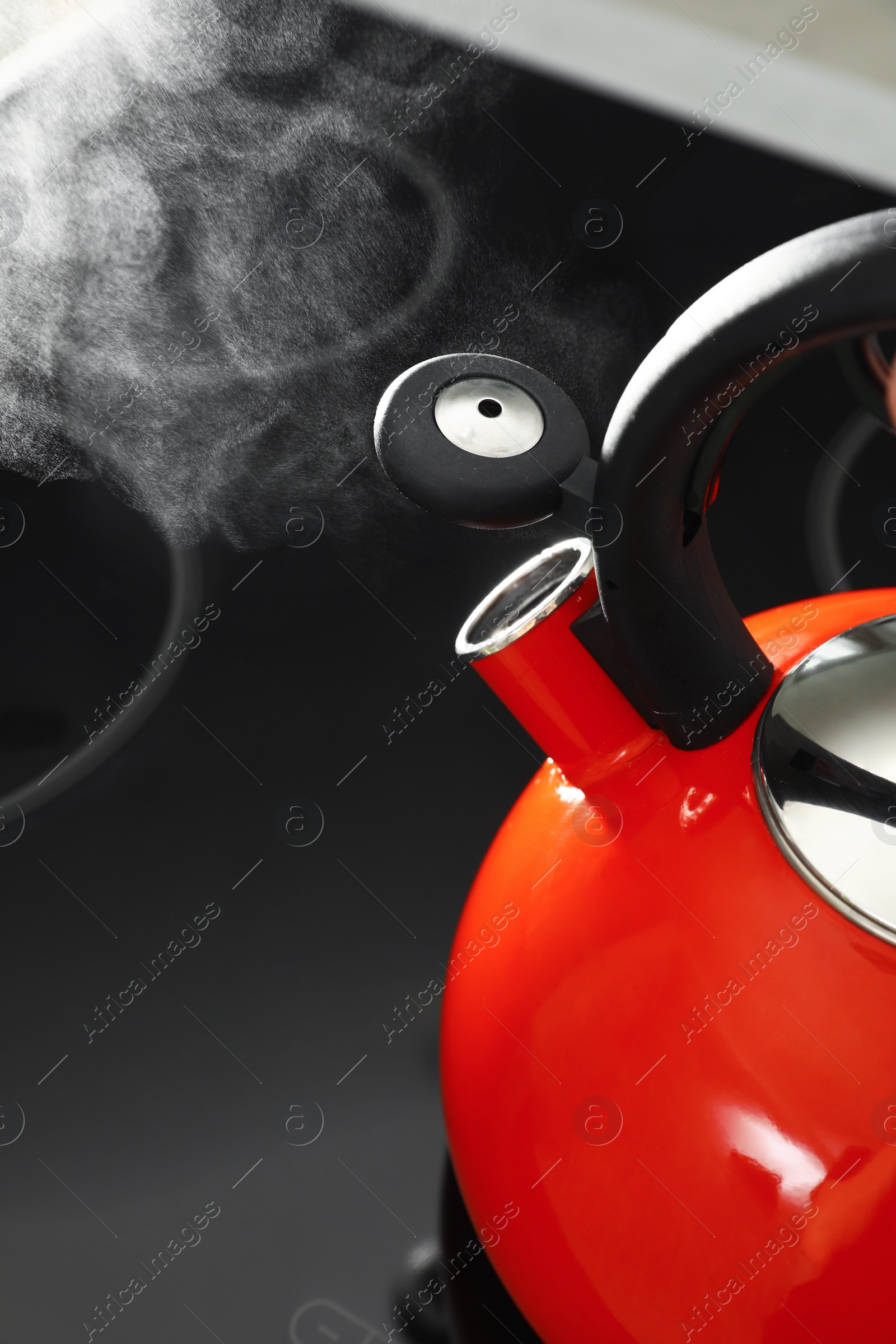 Photo of Modern kettle with whistle on stove, closeup. Space for text