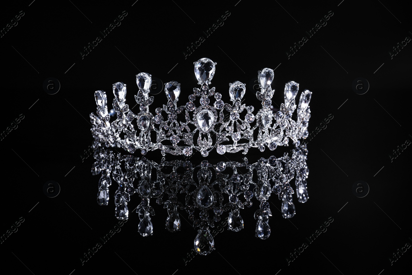 Photo of Beautiful silver tiara with diamonds on dark mirror surface