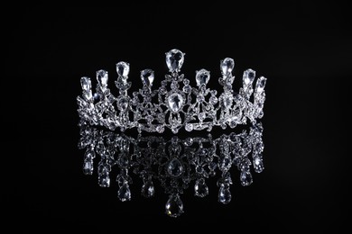Beautiful silver tiara with diamonds on dark mirror surface