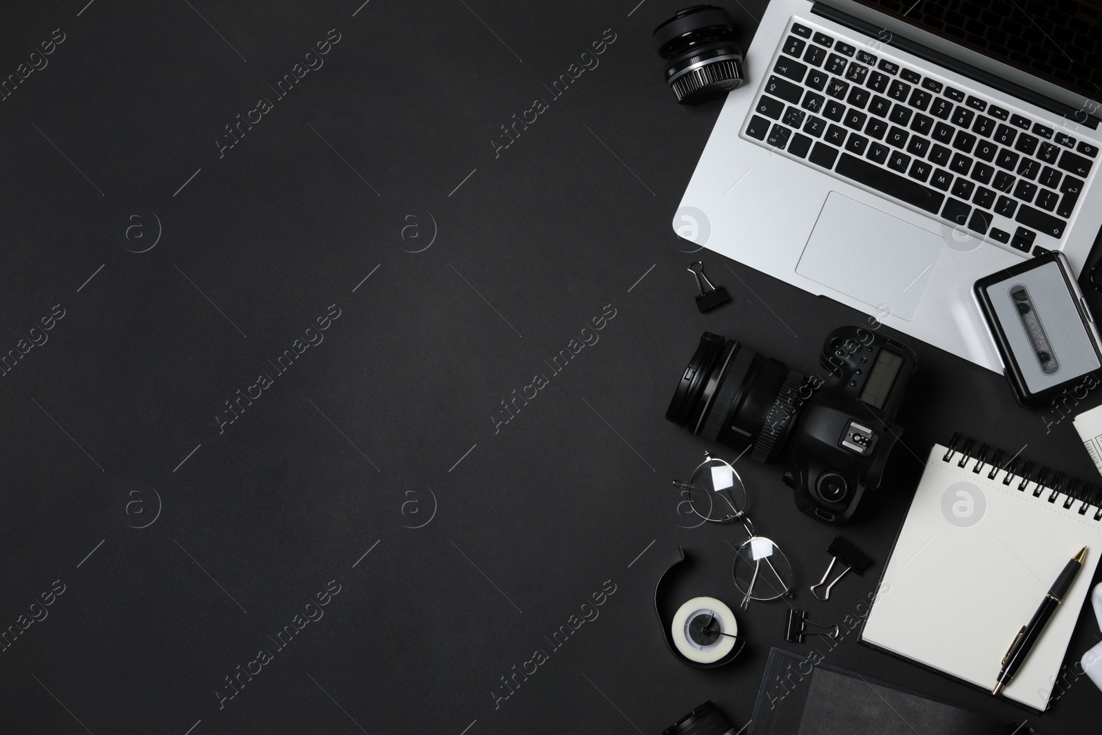 Photo of Flat lay composition with equipment for journalist on black background. Space for text